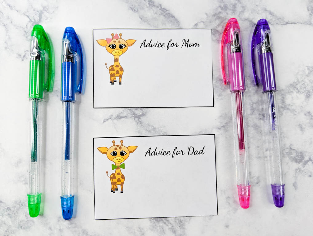 advice cards for mom and dad with a giraffe on them. set next to colored gel pens.