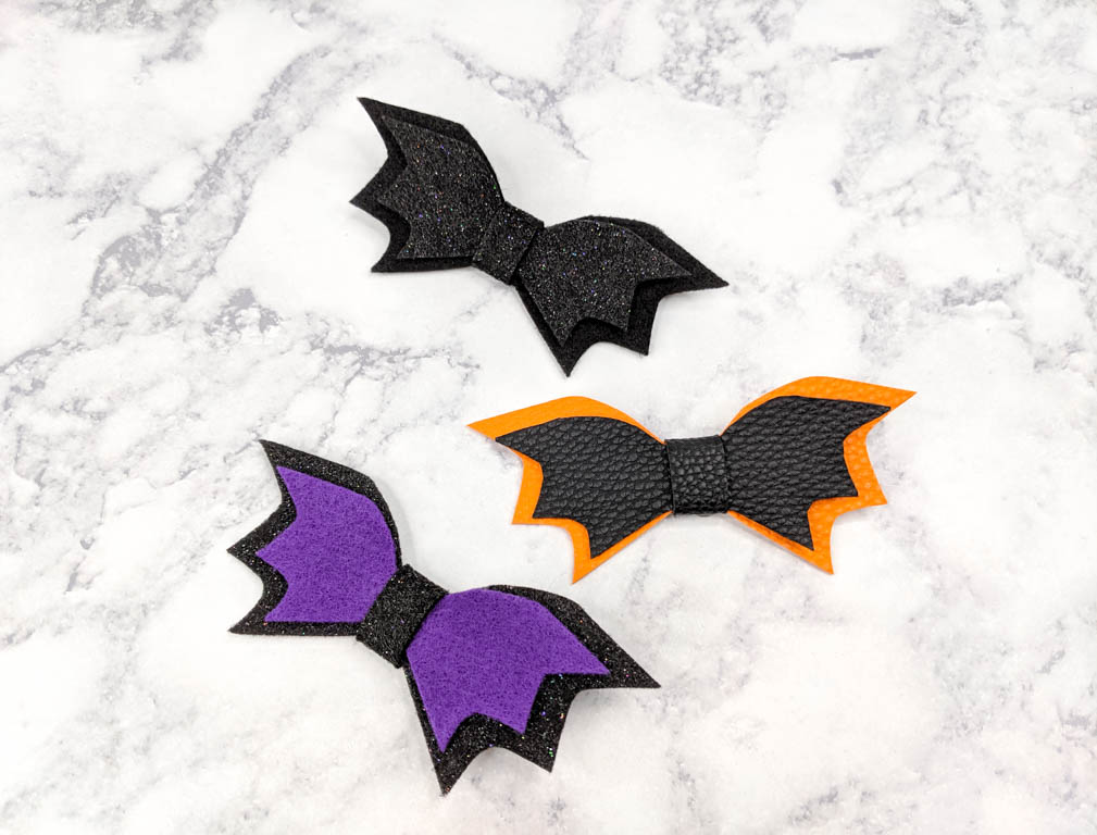 Three bat hair bows. All have different colors within their layers. 