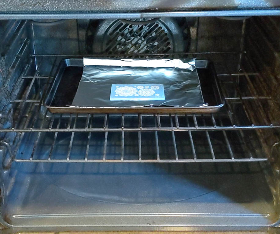 mold placed on tin foil, placed on a baking sheet. shown in the oven.