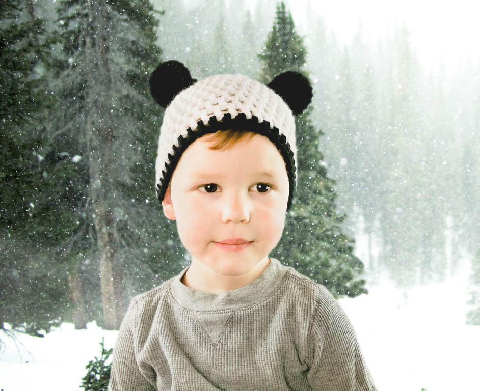 little boy wearing a crochet bear hat. Panda bear style.