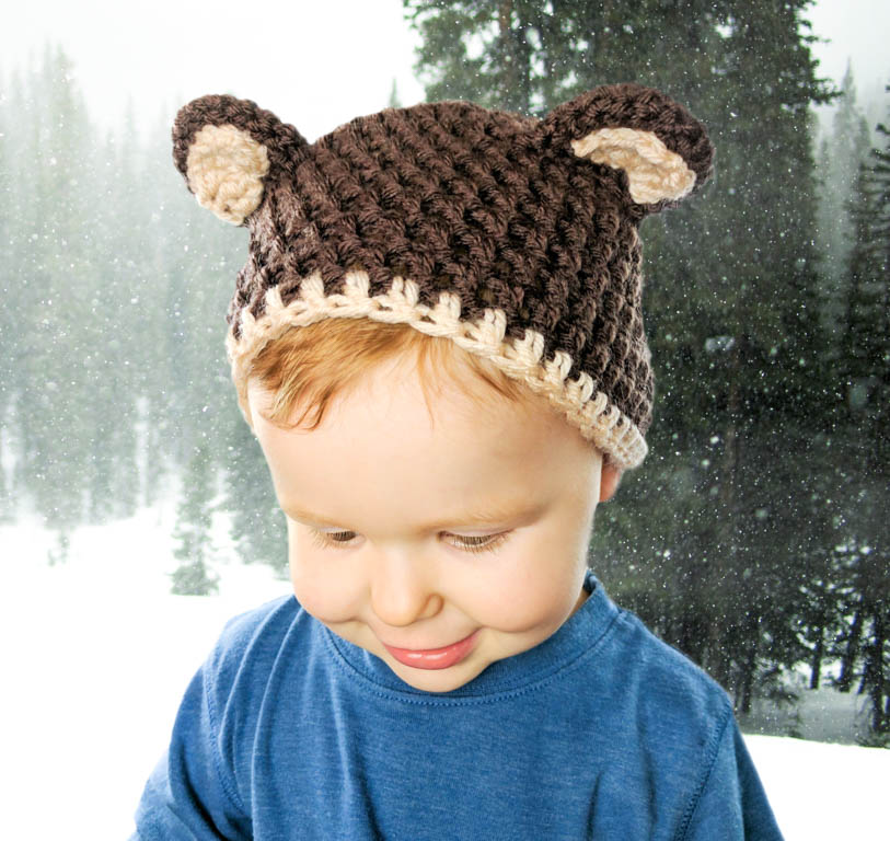 Toddler wearing a crochet bear hat. Brown bear style.