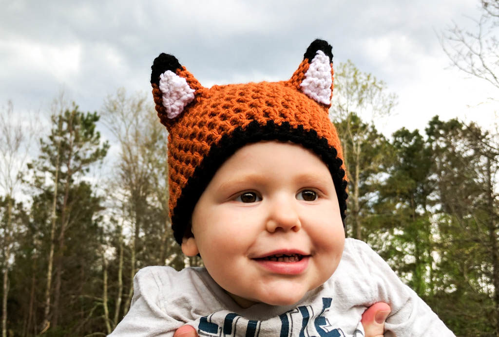 Toddler wearing a crochet fox hat