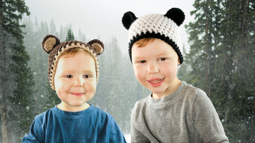 two little boys wearing crochet hats. One is a brown bear, one is a panda bear.