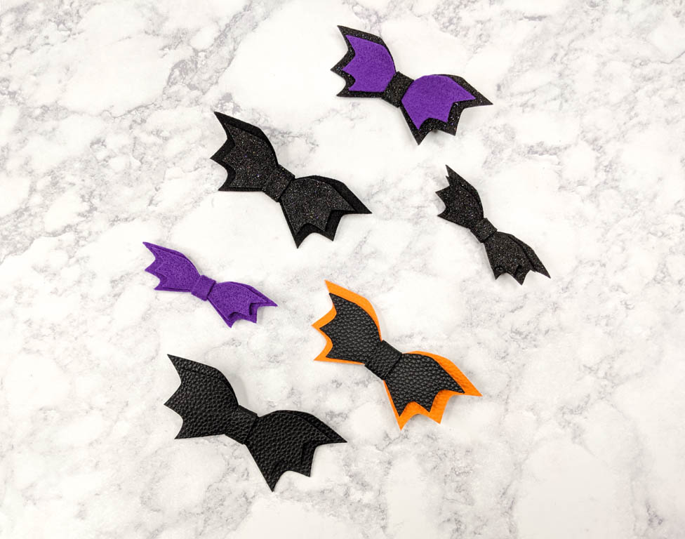 several bat hair bows in various sizes and colors