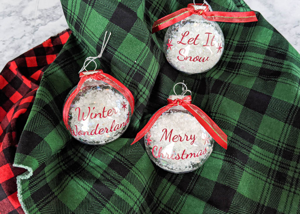 Clear Christmas ornaments with christmas sayings on them.
