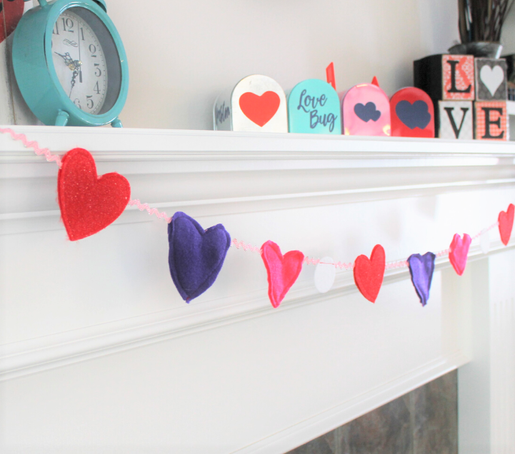 Heart garland made with felt and rickrack. Displayed across a fireplace mantel.