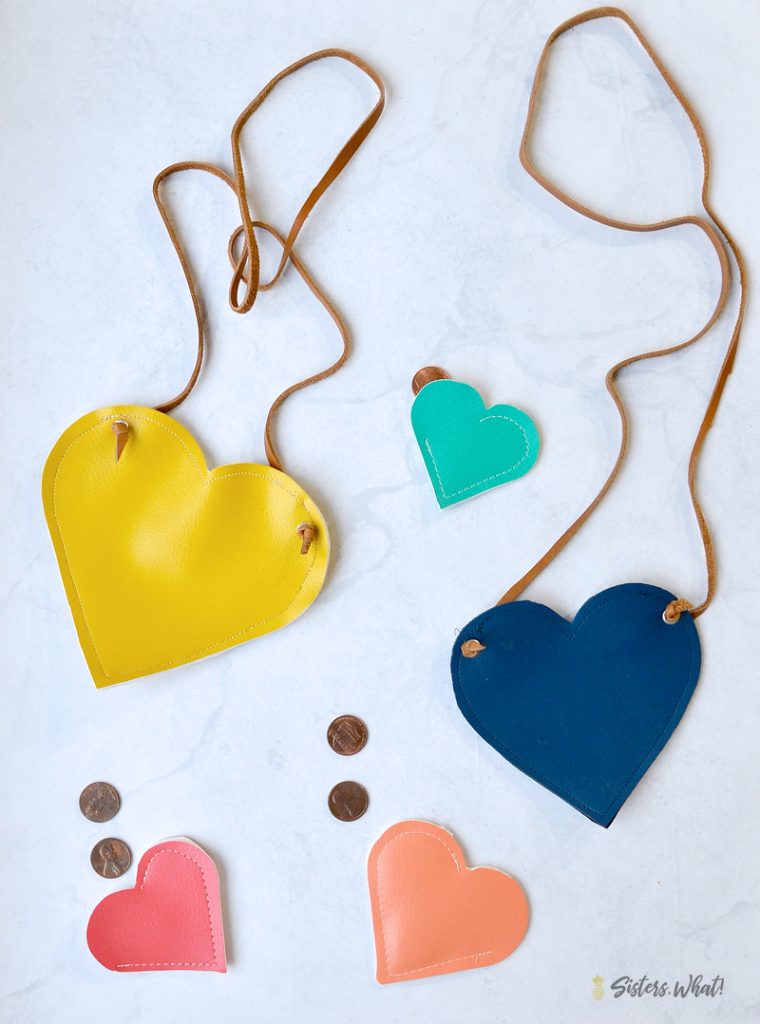 Five heart bags. two are larger with straps, three are smaller coin pouches.