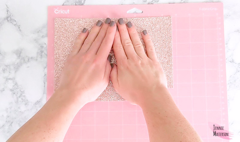 Loading glitter canvas onto a cutting mat.