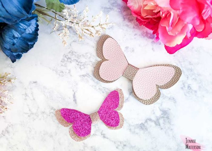Two butterfly hair bows displayed by flowers.