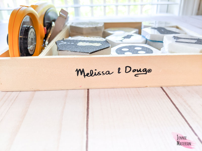 Showing the wooden box with the melissa and doug branding on it.