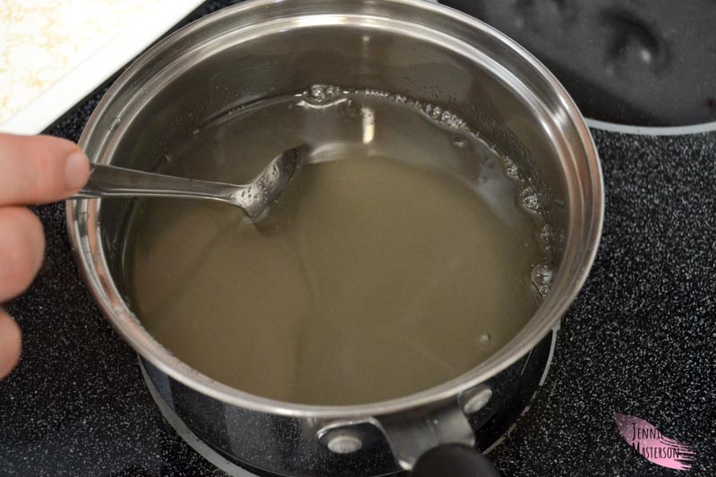 Stirring the sugar and water in a pan.