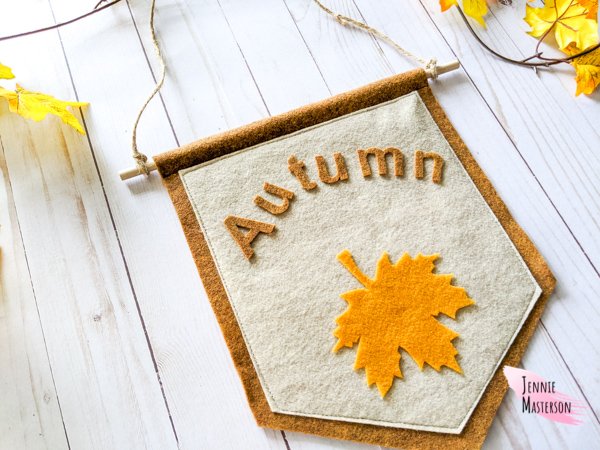 Fall sign wall hanging reading "Autumn" with an image of a leaf.