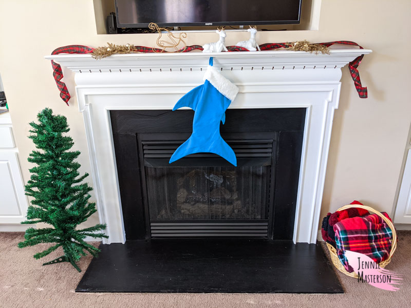 Finished shark stocking hung on a fireplace mantel.