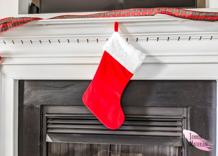 Traditional Christmas stocking hung on a fireplace mantle.