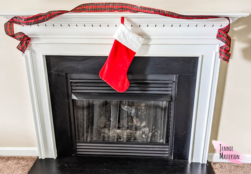 Traditional Christmas stocking hung on a fireplace mantle.