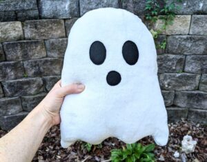 Person holding a ghost plushie. The perspective is from the persons point of view.