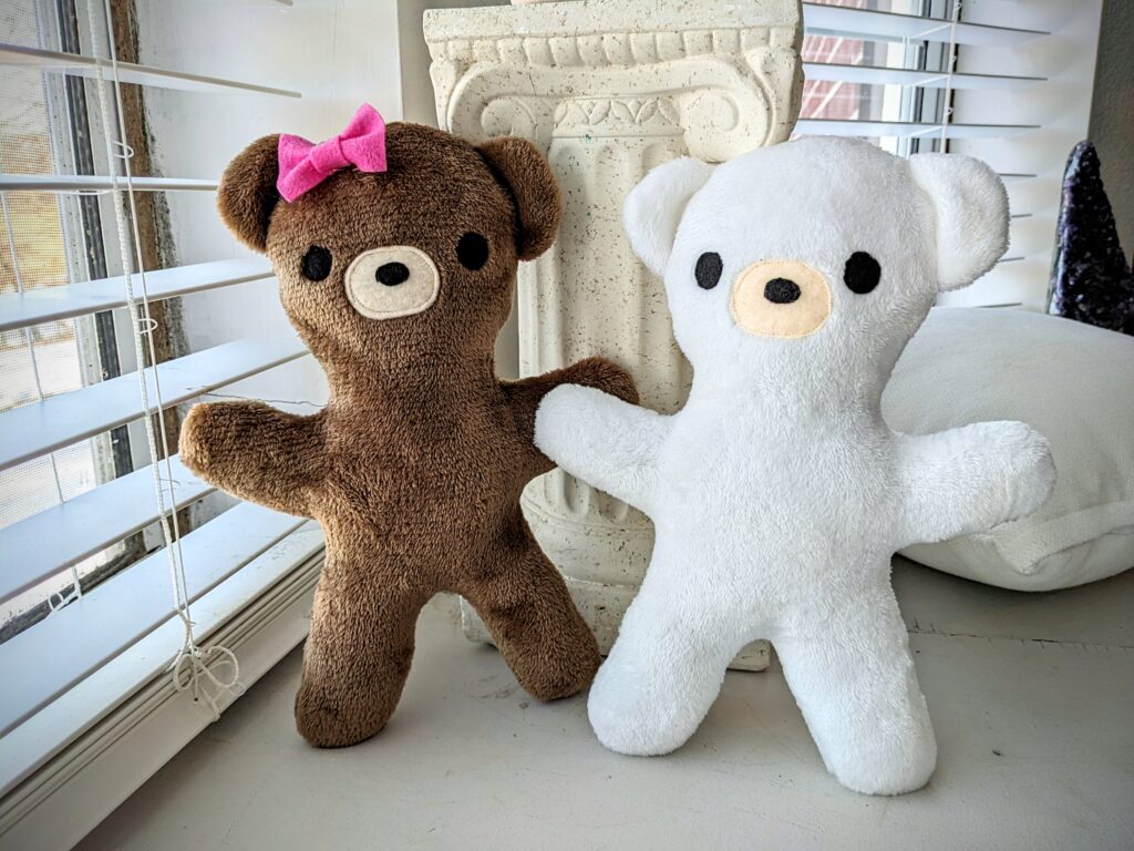 two bear plushies side by side. One is brown, one is white.