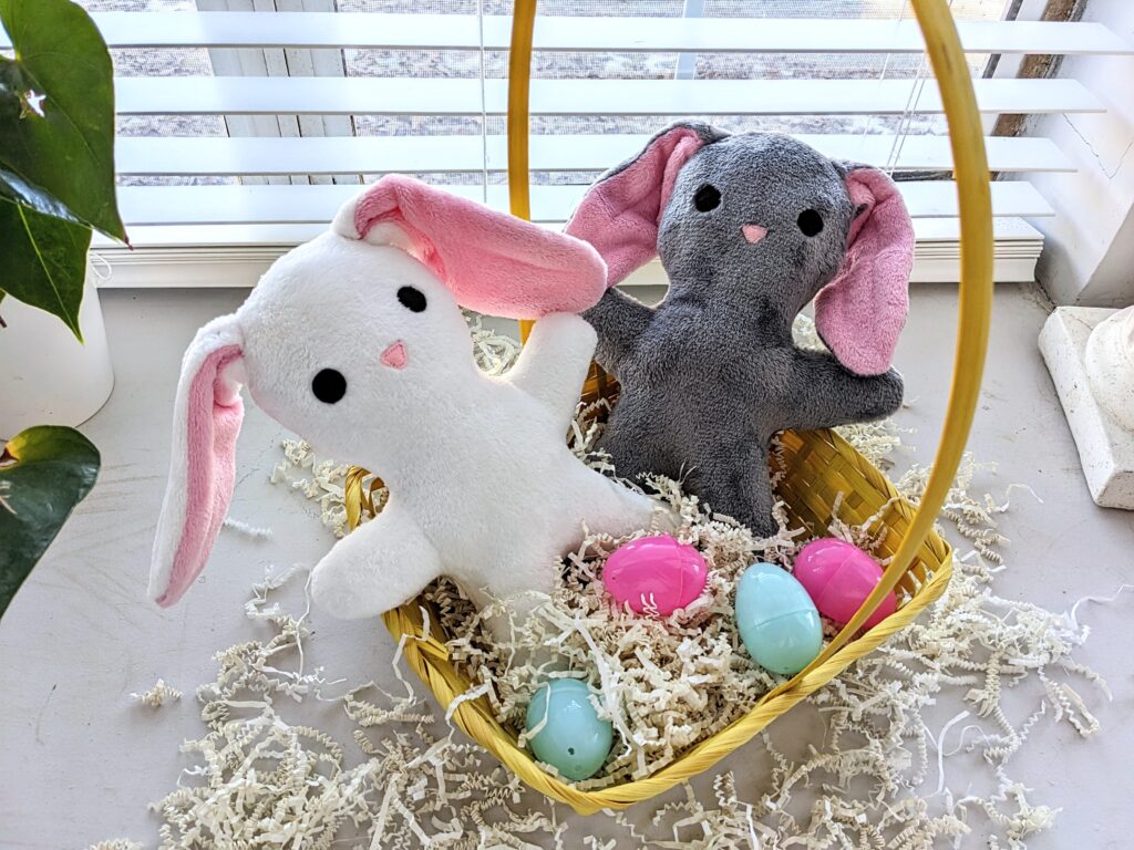 two bunny plushies in a yellow Easter basket.