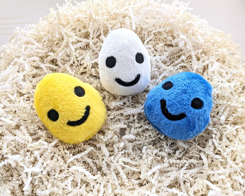 egg plushies with smiley faces